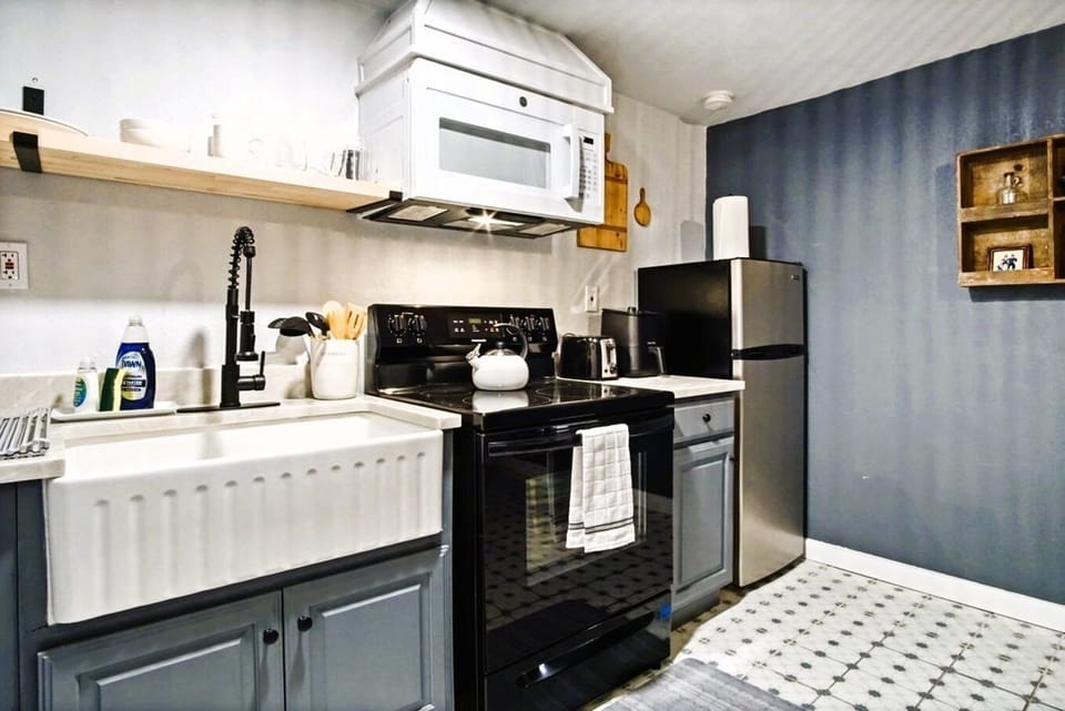 Kitchen — farmhouse sink, electric stove, stainless fridge.