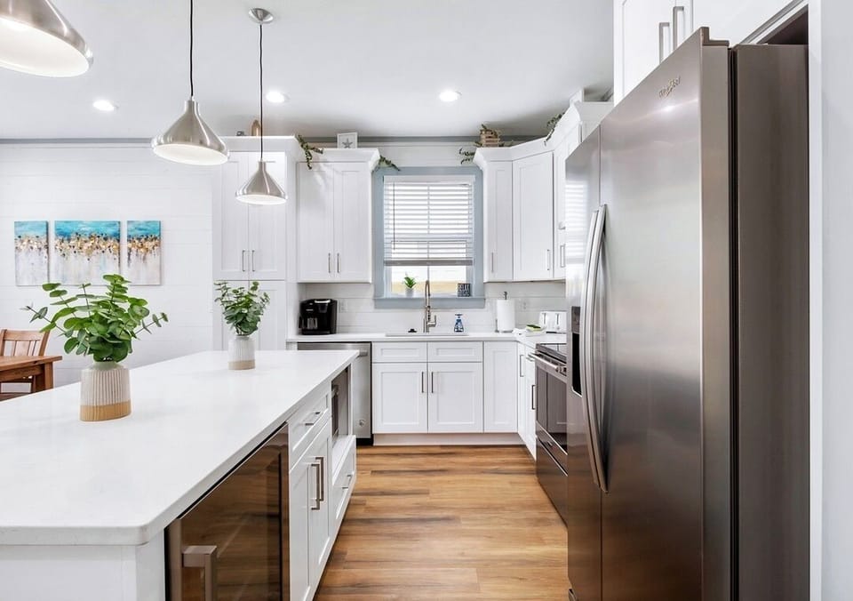 1st Floor - Fully stocked kitchen with quartz countertops, stainless steel appliances, and a large island with seating for 5—perfect for preparing meals and gathering with the whole group!