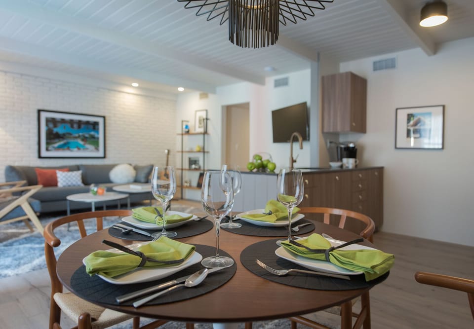 Dining area set for four with open flow to the kitchenette and stylish living space.