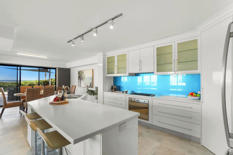 Dining area positioned beside a bright, contemporary kitchen