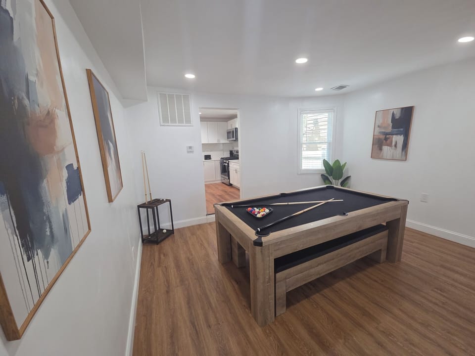 Bright modern game room with pool table and easy kitchen access