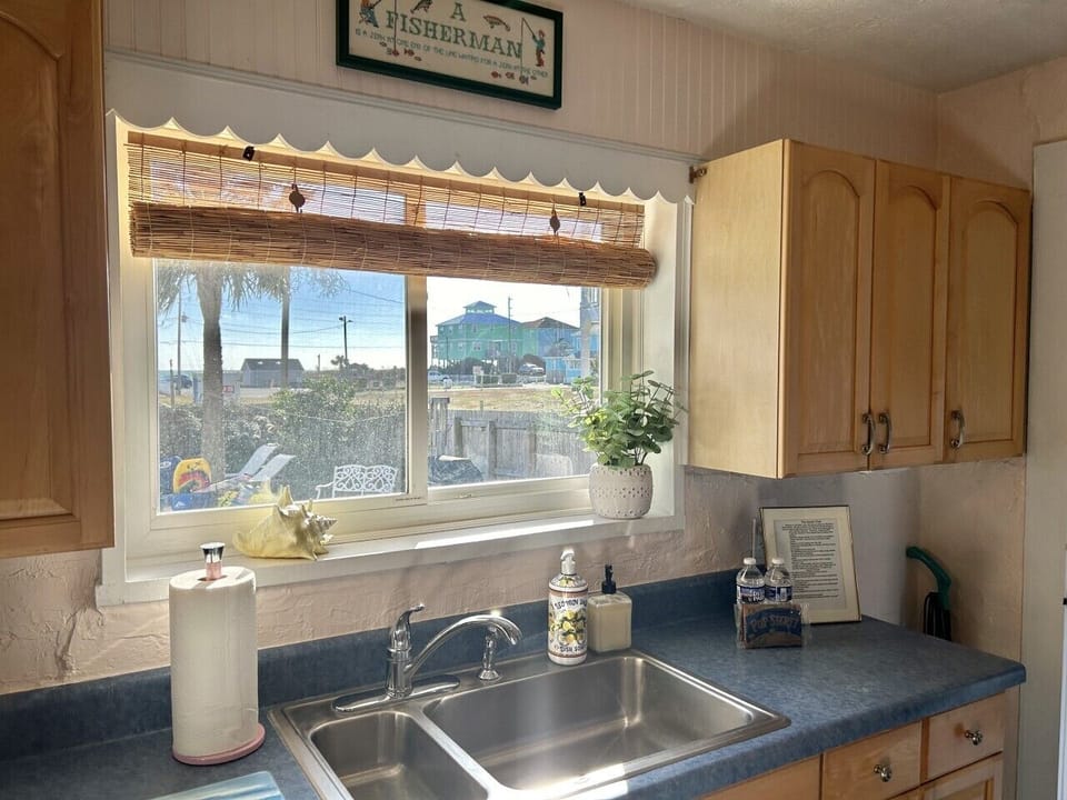 Well-equipped kitchen with generous counter space, natural light, and a welcoming coastal atmosphere
