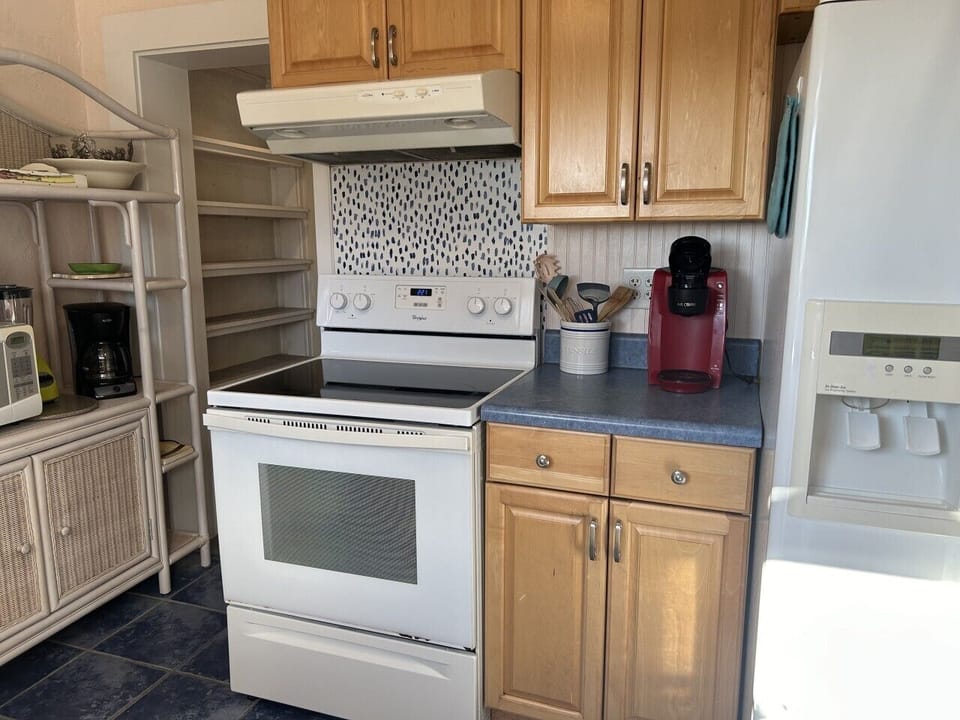 Prepare favorite meals with ease in this well-stocked kitchen featuring essential appliances and convenient counter space