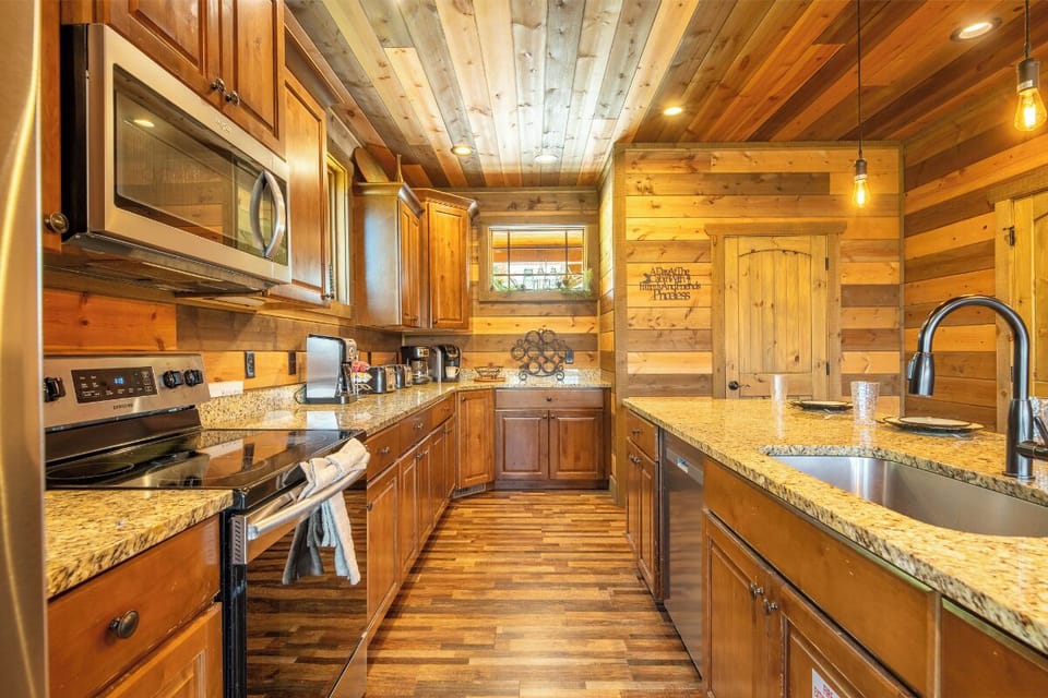 Step into your fully equipped kitchen where rustic wood plank ceilings and warm pendant lighting create a cozy mountain cabin feel. Granite countertops, stainless appliances, and all the amenities you need make cooking a pleasure during your stay.