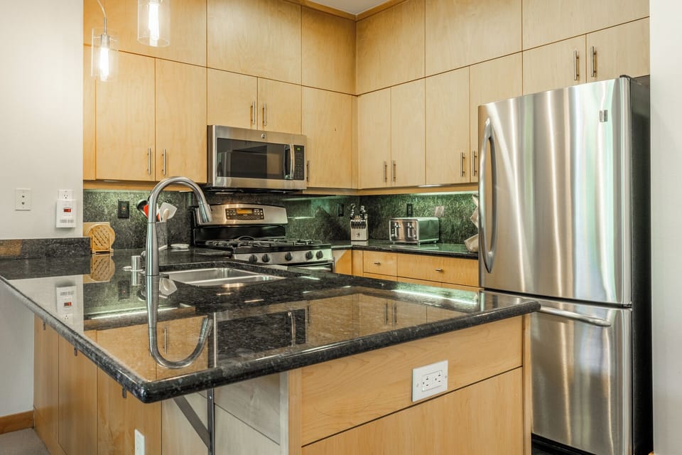 Your fully equipped kitchen features sleek stainless-steel appliances, granite countertops, and ample cabinet space—perfect for preparing meals and gathering with loved ones.