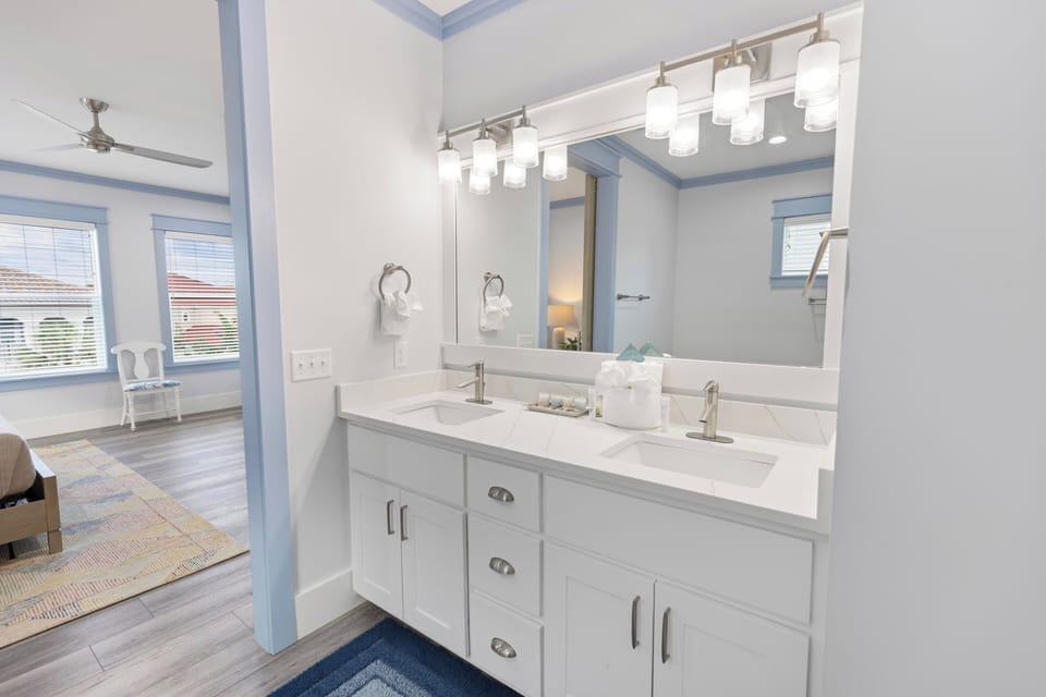 Step into your pristine ensuite with dual sinks, modern fixtures, and elegant lighting. Fresh towels await as natural light fills the space, creating your perfect morning routine.