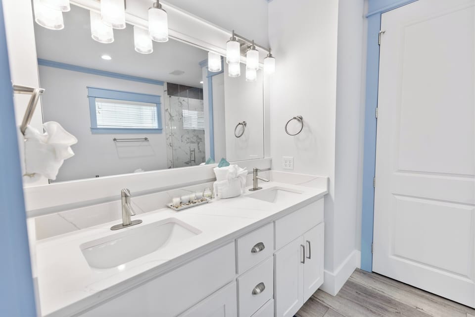 Step into your bright, spa-like bathroom with dual sinks, elegant lighting, and a sleek walk-in shower, all designed for your ultimate comfort.