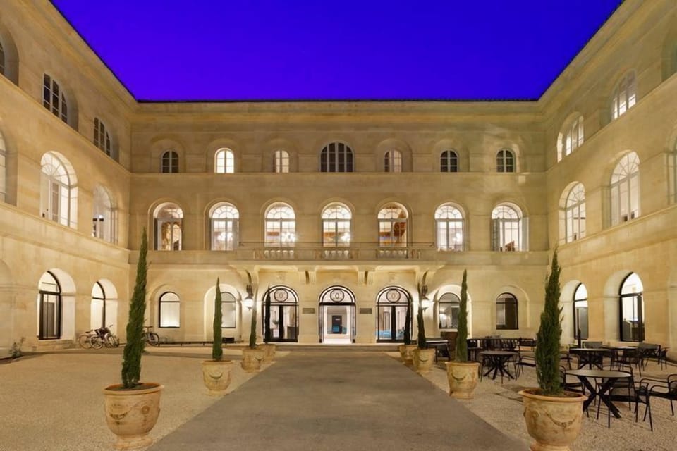 The illuminated inner courtyard by night — a defining feature of this former Consular Hotel, listed as a historic monument.