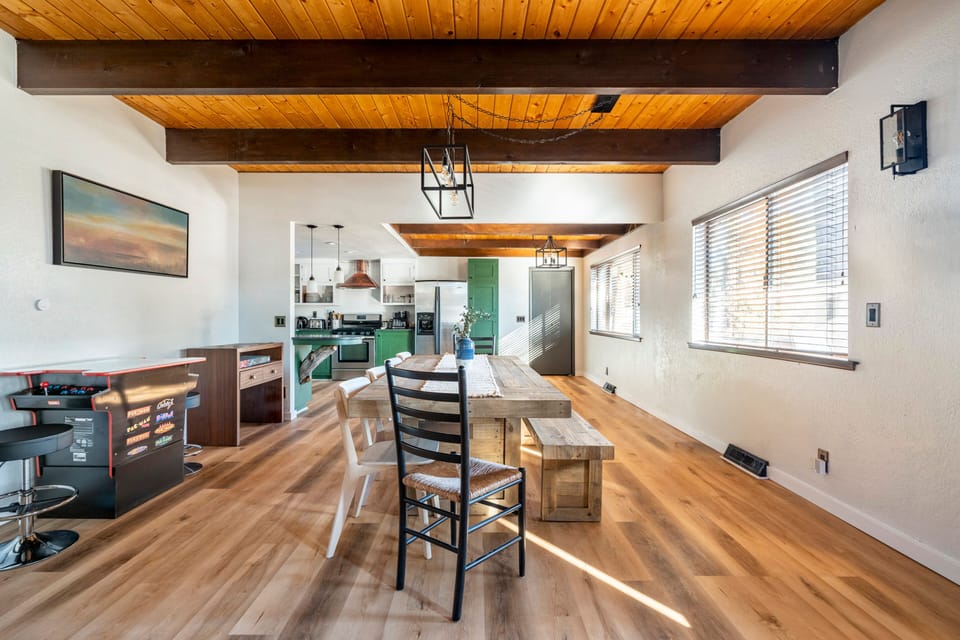 Sunny open-plan dining with farmhouse table and stylish kitchen
