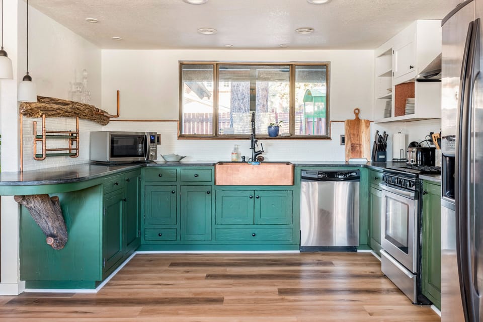 Stylish kitchen with copper farmhouse sink & stainless appliances