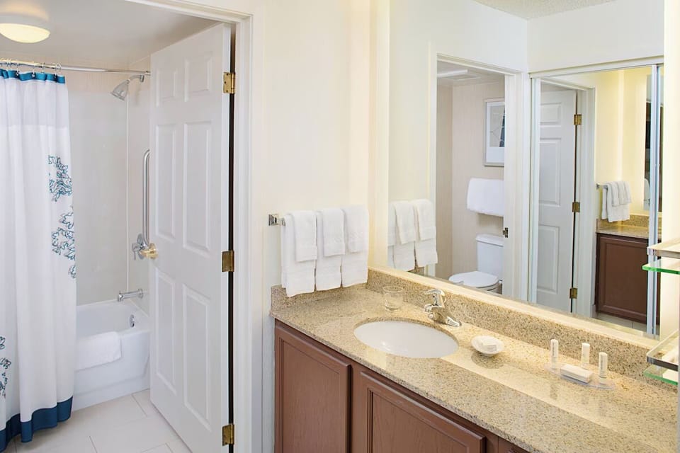 Refresh in a bright bathroom with vanity, mirror, and tub shower.