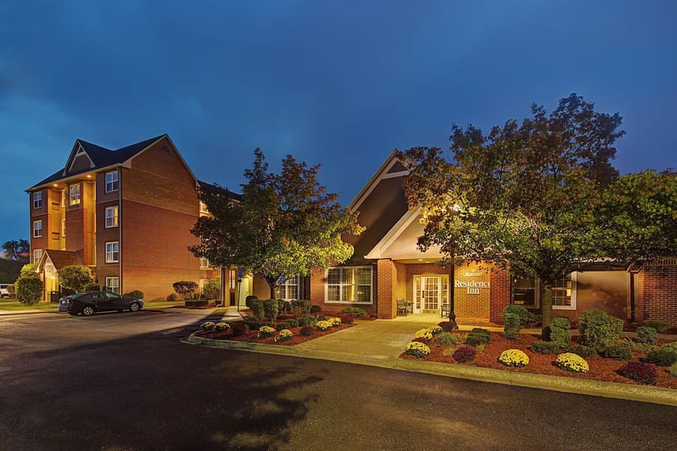 Pull up to a beautifully lit, welcoming hotel entrance at dusk.