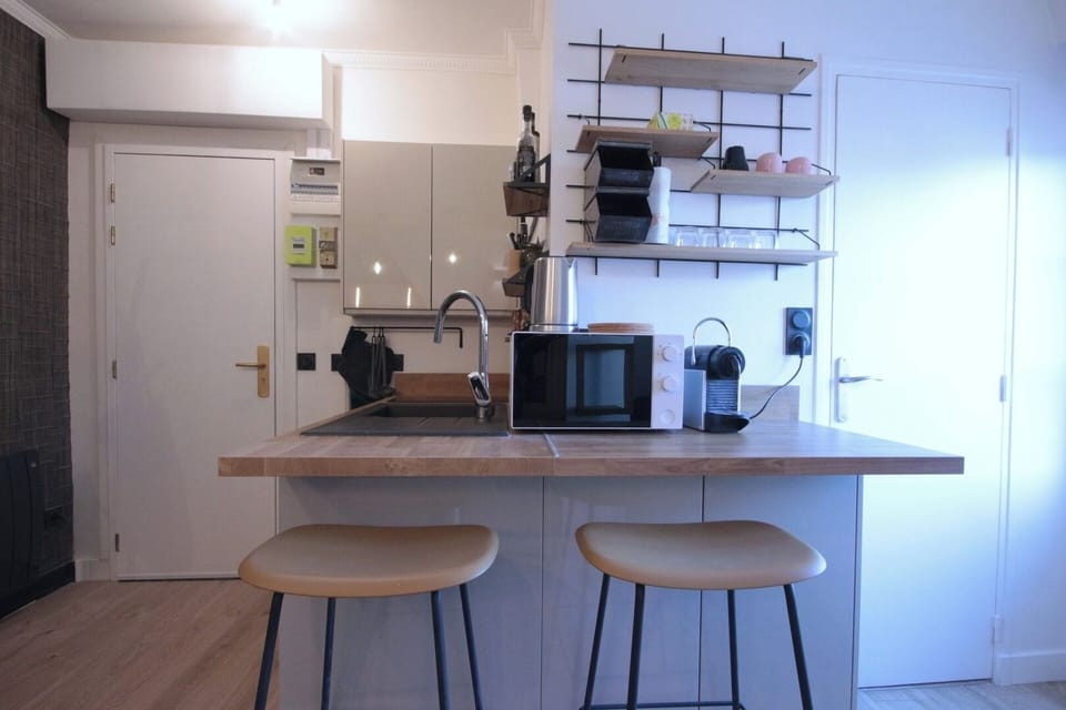 Cuisine ouverte équipée avec espace repas, parfaite pour un séjour de plusieurs semaines