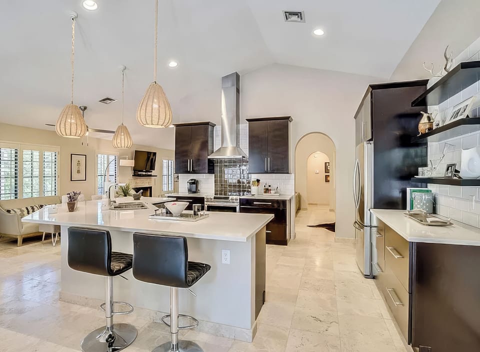 Bright open kitchen with island seating, pendant lighting, and easy flow to the living area.