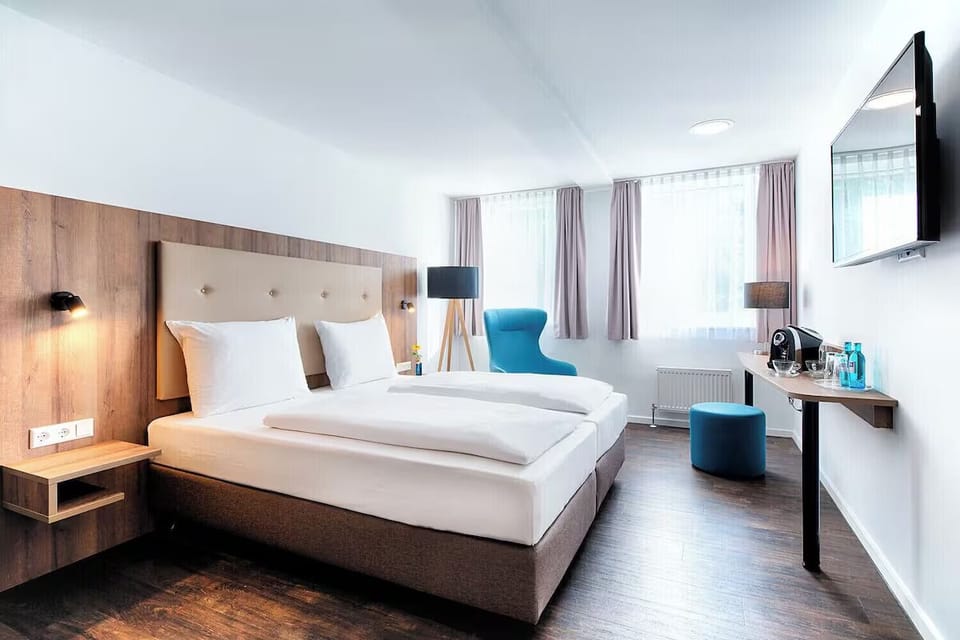 Arrive and relax in a sunlit bedroom with modern comforts.