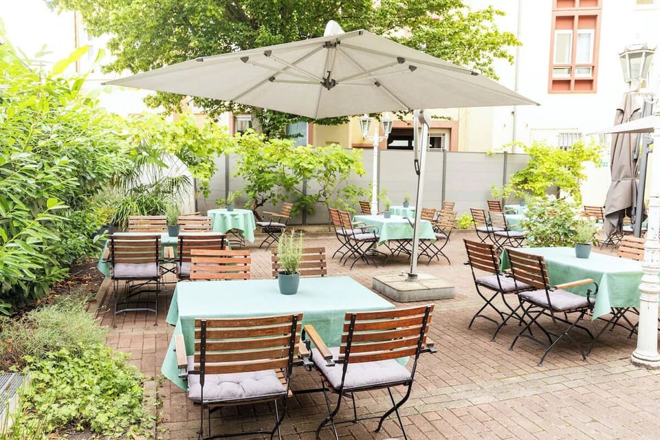 Linger over drinks beneath umbrellas in a leafy courtyard.