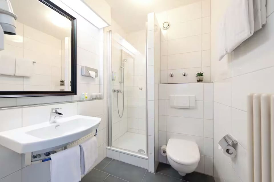 Refresh under a sleek shower with crisp towels and bright tiles.