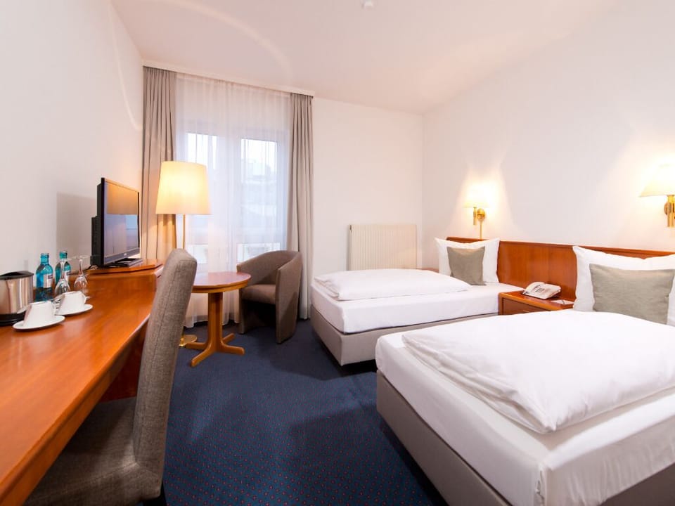Settle into twin comfort with workspace and soft evening lighting.
