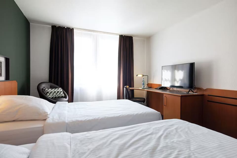 Unwind in bright twin beds with desk and TV.