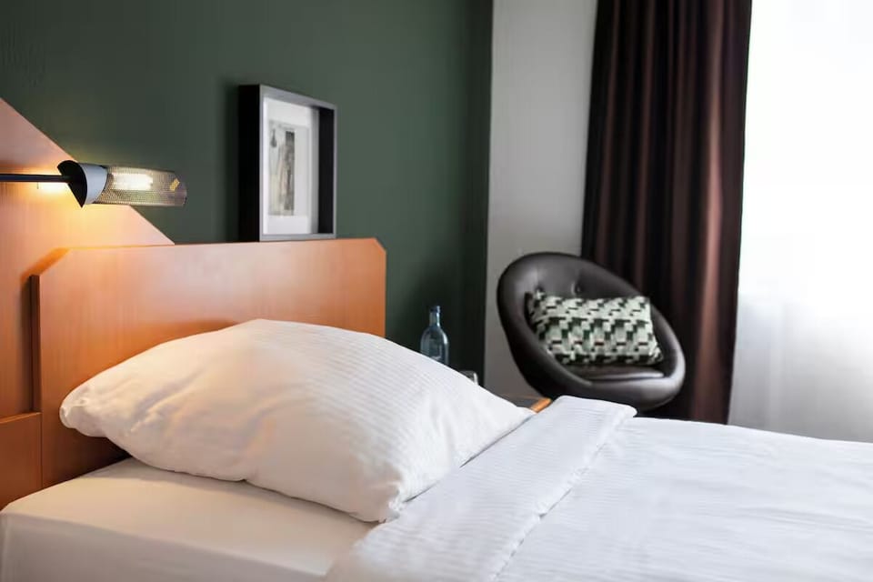 Sink into crisp linens beside warm reading lights.