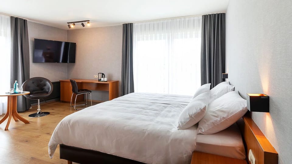 Unwind on crisp linens in a bright, airy room.