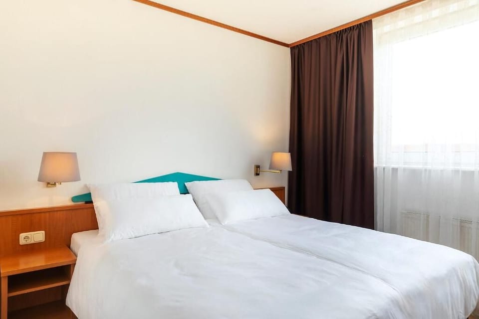 Drift off under fluffy duvets in a serene, simple space.