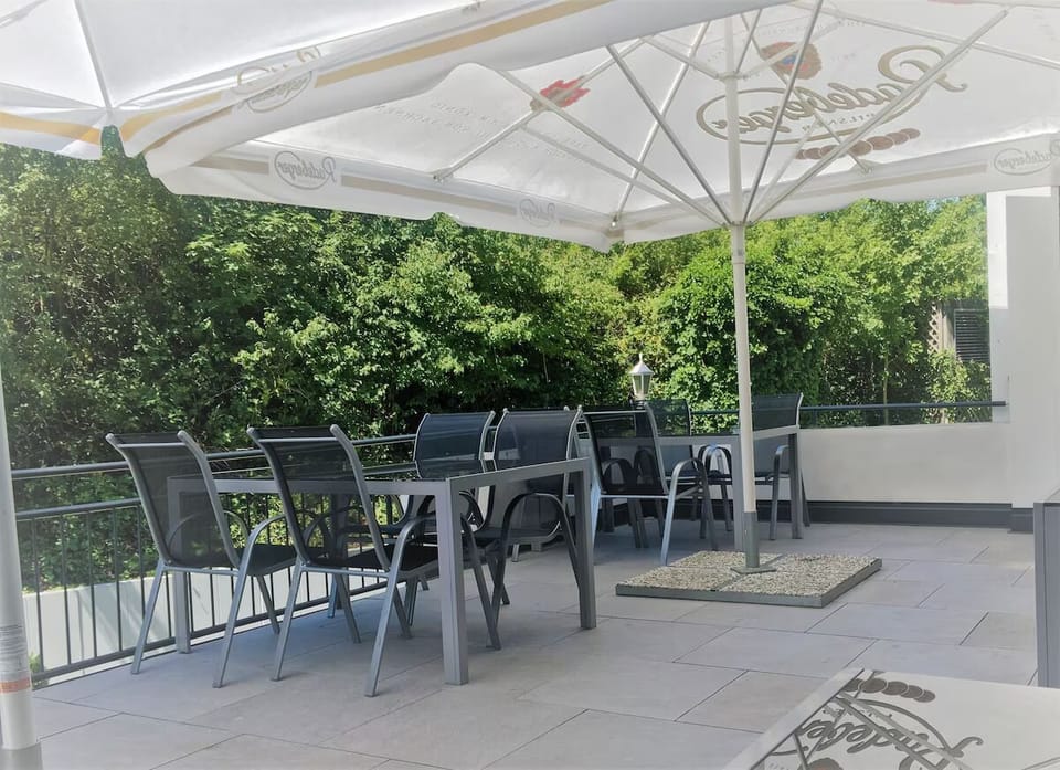 Sip morning coffee outside under shade with leafy views.