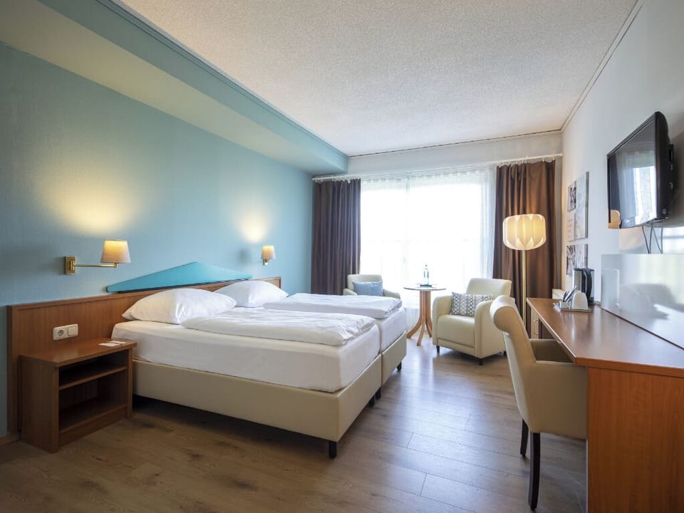 Stretch out and relax in a spacious room with calming tones.