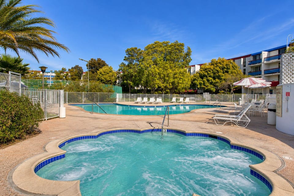 Resort-style pool and spa with sunny lounge deck and tropical surroundings