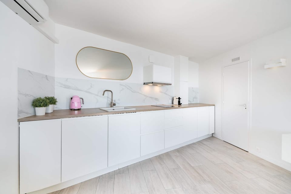 Au petit matin, le miroir doré capte la lumière tandis que la bouilloire rose siffle. Préparez un café à la machine, installez‑vous au calme climatisé et sentez l'ambiance douce et épurée de la cuisine.