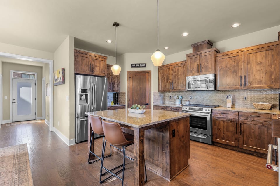 Your gourmet kitchen features rich wood cabinetry, granite countertops, stainless appliances, and a spacious island—perfect for preparing meals and gathering with loved ones.