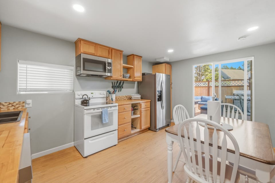 Prepare meals with ease in your fully-equipped kitchen, featuring modern appliances, ample counter space, and natural light streaming through the windows. The adjacent dining area leads to your private patio.