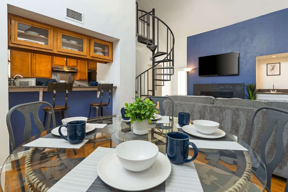 Spacious living area with stylish spiral staircase and modern amenities, perfect for relaxing or entertaining.