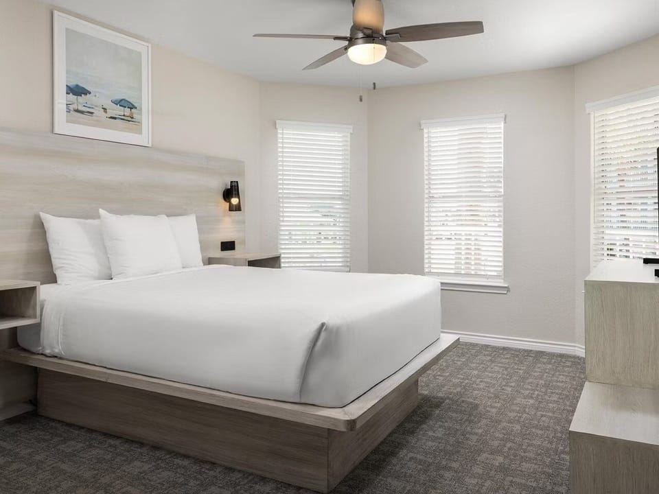 Sink into a cloud-soft king bed under a breezy ceiling fan.