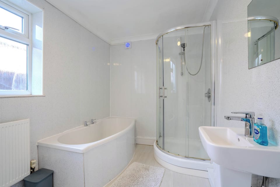 Freshen up in the bright bathroom, featuring both a relaxing bath and a separate shower.