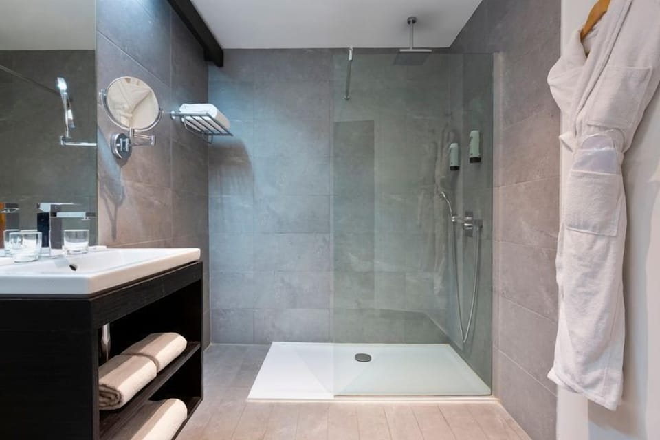 The modern en-suite bathroom features a spacious walk-in shower and clean-lined finishes, complementing the contemporary style of this wing of the property.