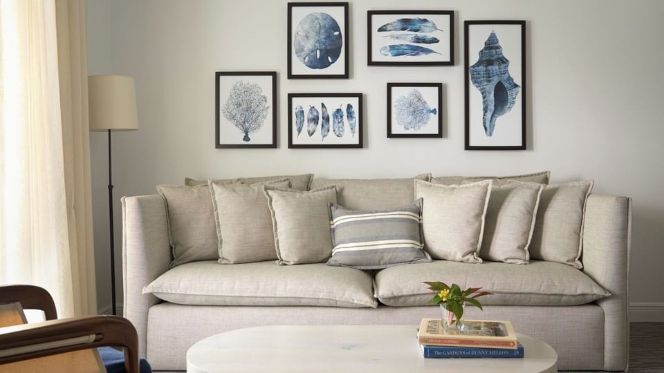 Unwind on the plush sofa beneath calming coastal-inspired artwork.