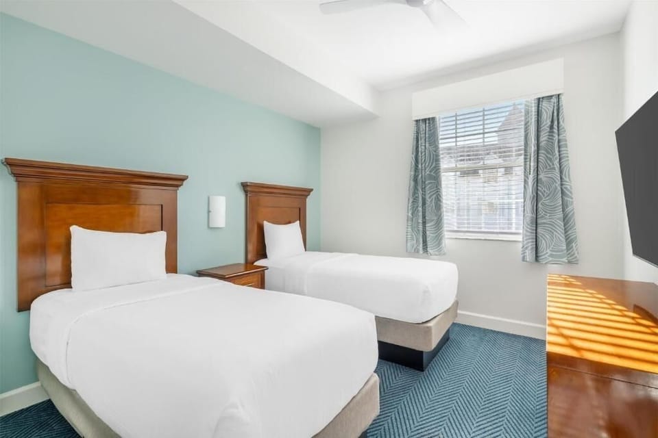 Sleep comfortably in the bright twin room with soft bedding.