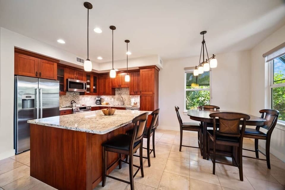 Full kitchen with granite island, pendant lighting, and seating for six