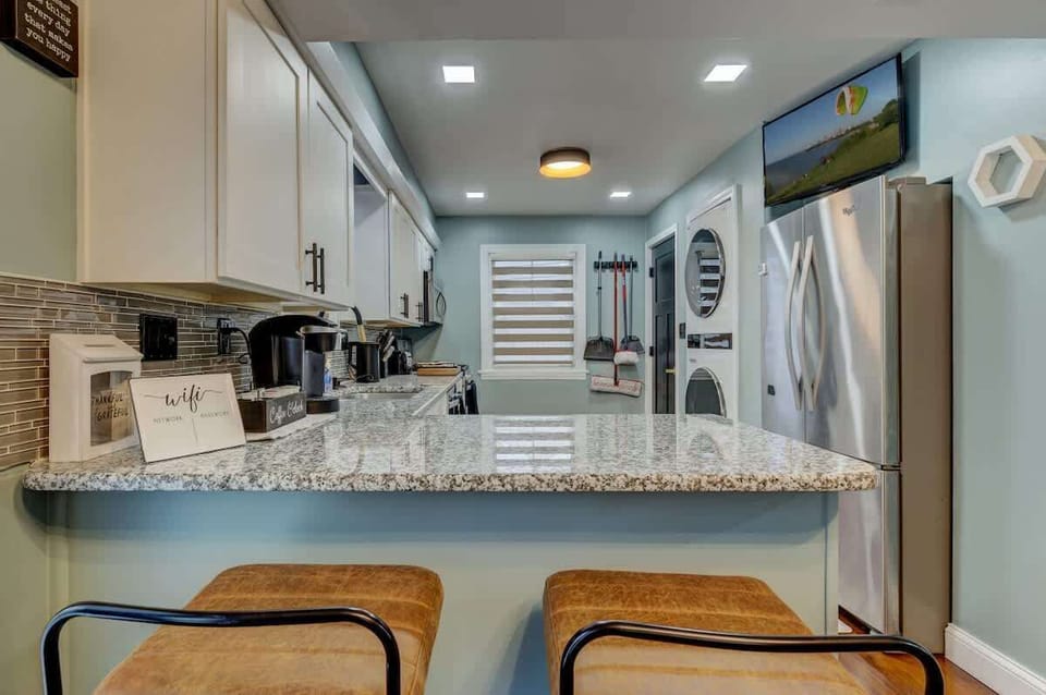 Kitchen island w/ bar stools & granite counters, ideal for casual dining