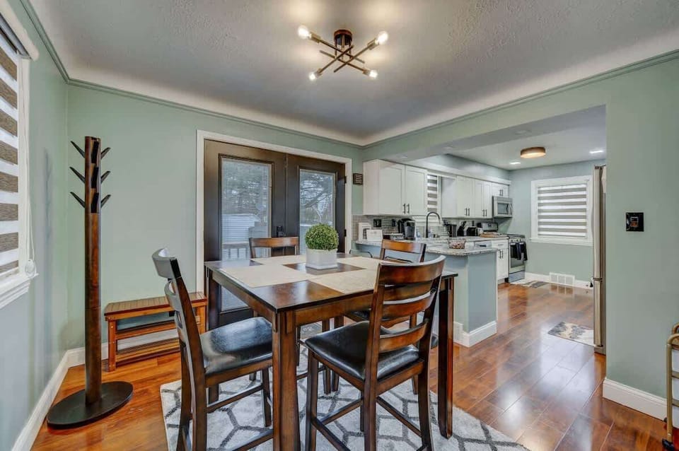 Dining area w/ wood table set for meals, flowing easily into the open kitchen space