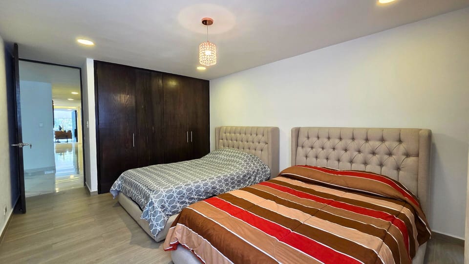 Spacious twin-bed room with large wardrobe and modern, cozy design