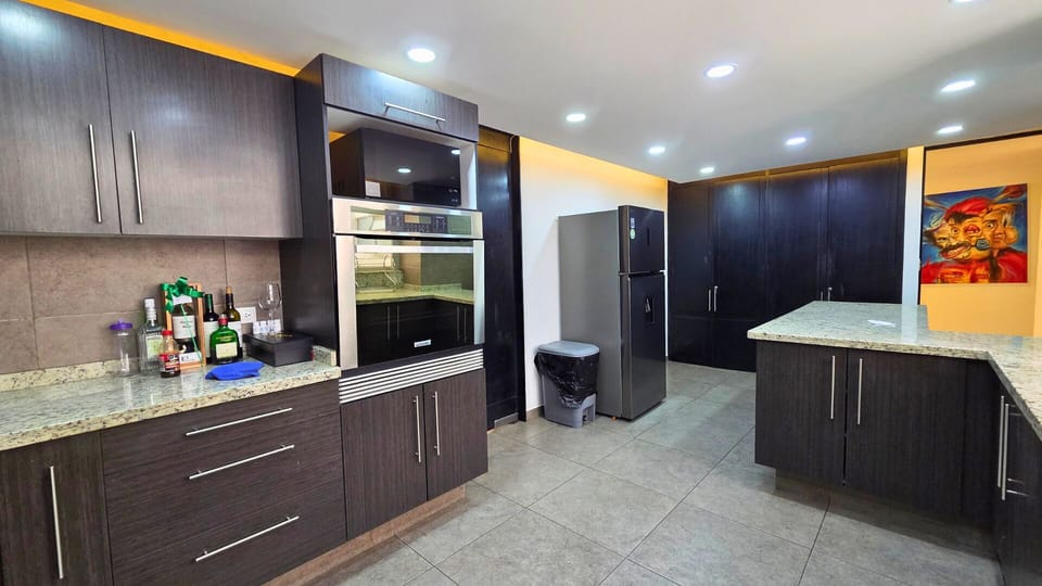 Spacious modern kitchen with granite counters and sleek dark cabinetry