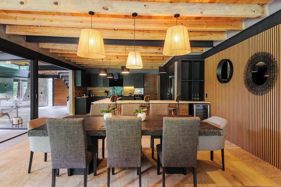 Round mirrors and soft pendant light dress this eight-seat dining table for shared meals.