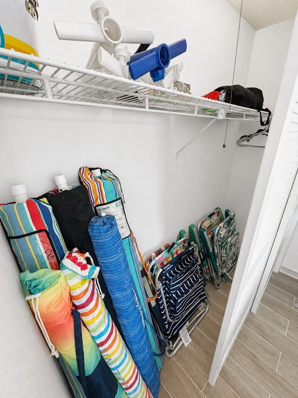 Beach gear closet with 6 chairs, umbrellas and essentials ready for guest use.