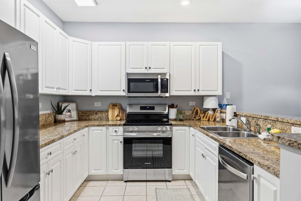 Granite countertops offer plenty of meal preparation space alongside a full range stove, microwave, and dishwasher.