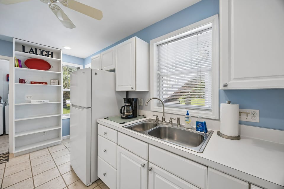 Spacious kitchen with white cabinets and appliances,