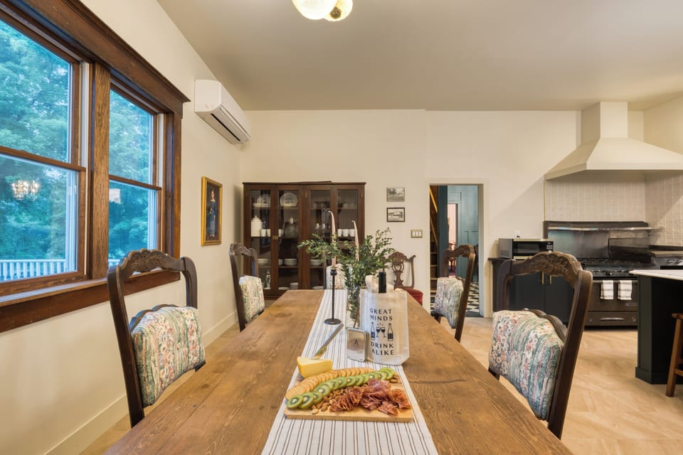 Dining area with historic woodwork, antique seating, and easy flow into the updated kitchen.