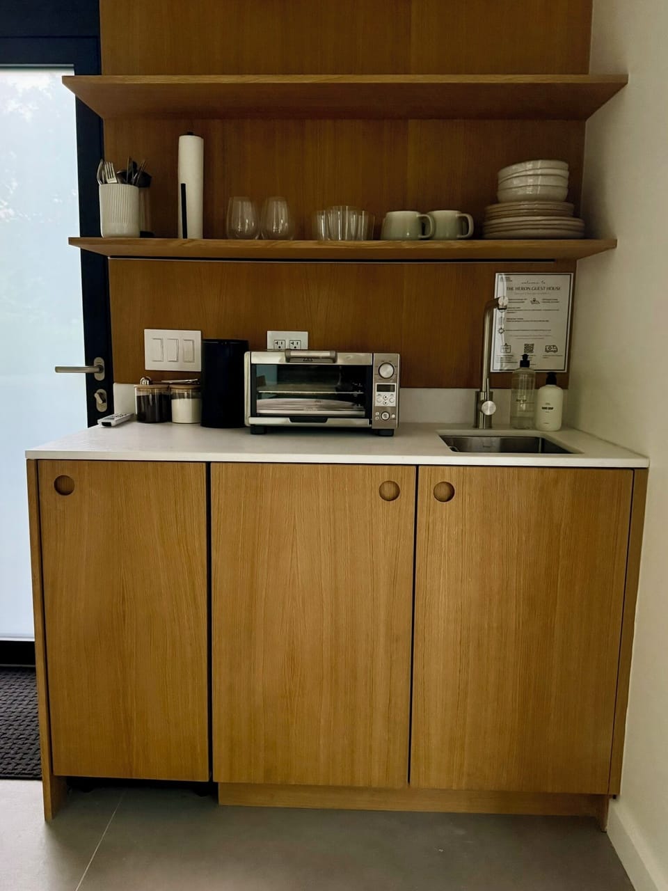 A tidy kitchenette stocked with coffee, a toaster oven, and the everyday essentials.
