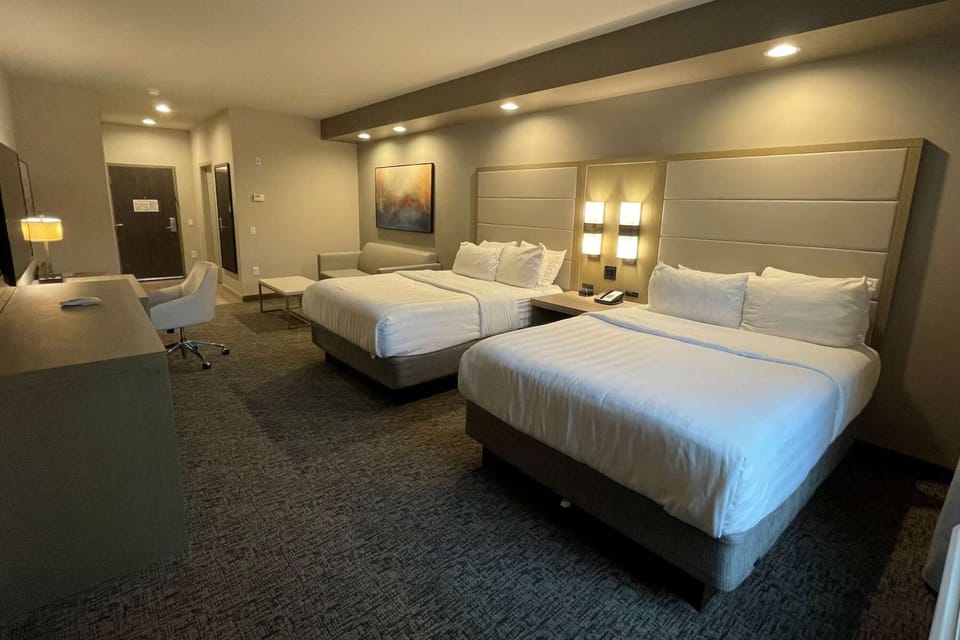 Queen suite two queen beds with sofa, desk, and modern lighting